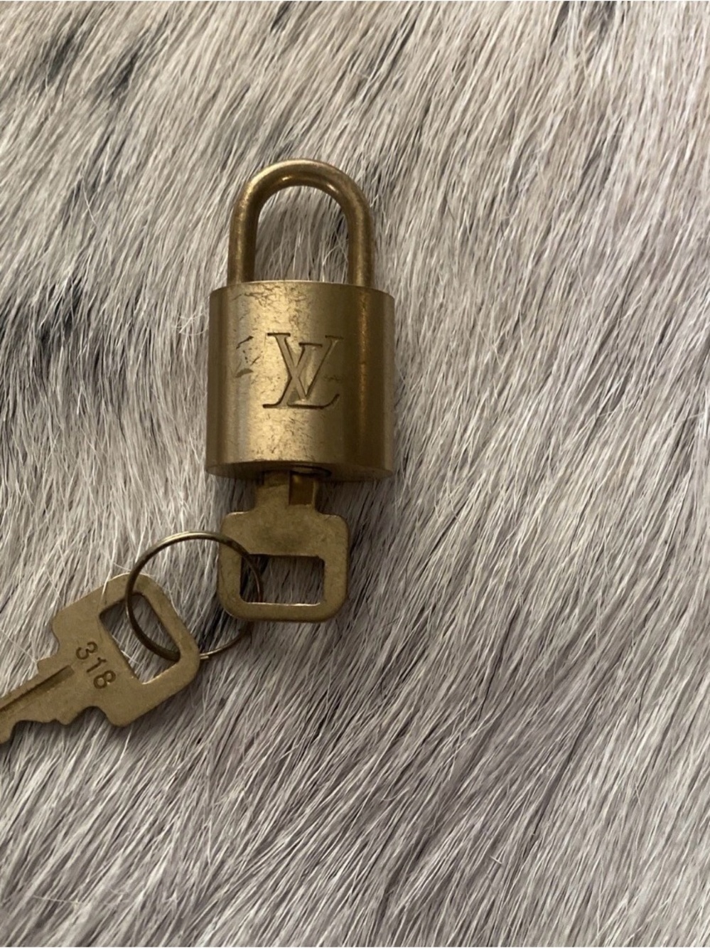 LOUIS VUITTON BRASS LOCK AND KEY SET.